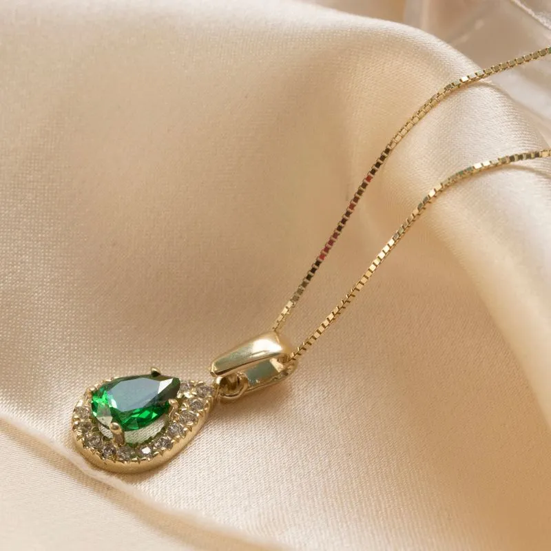 Yellow gold drop necklace with white zircons and a green zircon in the center