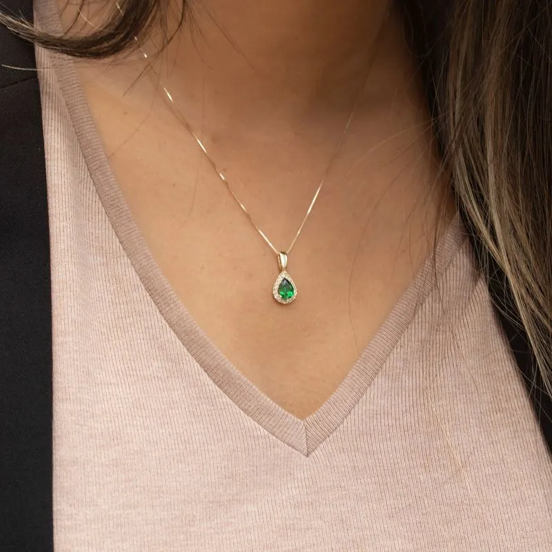 Yellow gold drop necklace with white zircons and a green zircon in the center